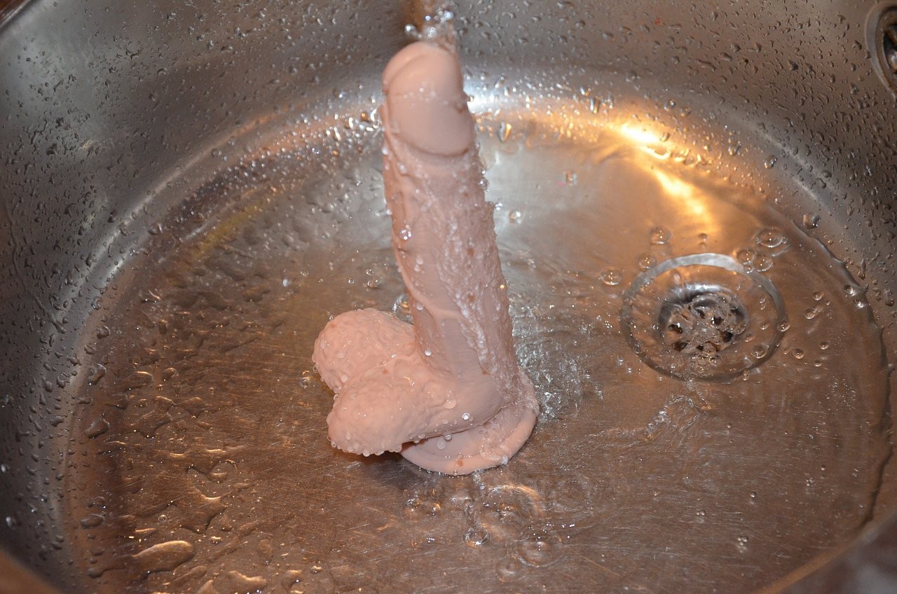 Dildo s přísavkou a varlaty Silicone (18 cm), pod proudem vody