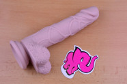 Dildo s přísavkou a varlaty Silicone (18 cm), leží na stole