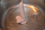 Dildo s přísavkou a varlaty Silicone (18 cm), pod proudem vody